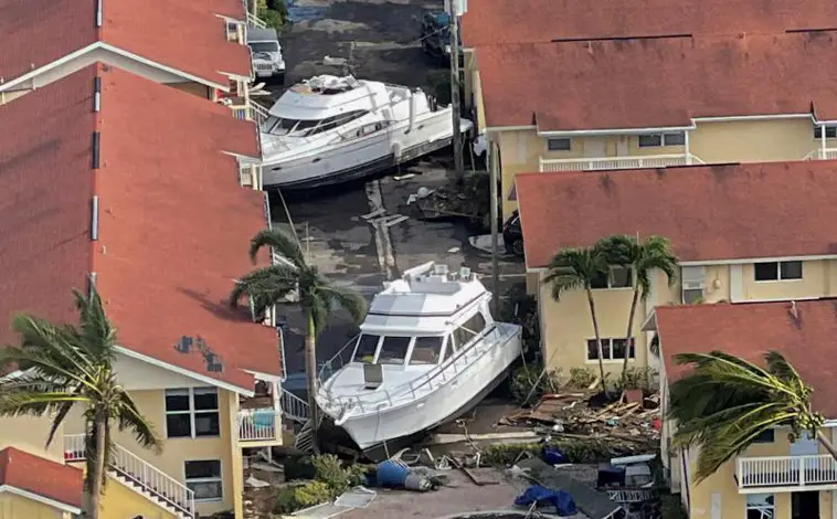 Imagen principal - Barcos en las calles de Fort Myers, puentes derruidos en Sanibel y calles todavía inundadas tras el paso del huracán Ian en Florida