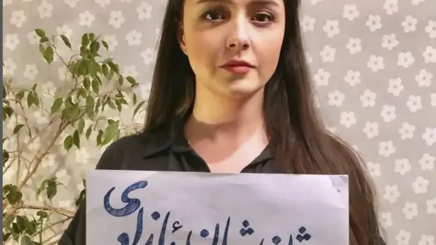 Photo en story Instagram de l'actrice Tarane Alidoost, sans foulard et tenant une pancarte sur laquelle elle a écrit le slogan des manifestations : 'Femme, vie, liberté'
