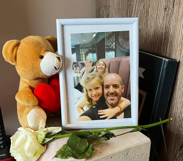 Imagen de la urna de la pequeña Emma junto a una fotografía con sus padres